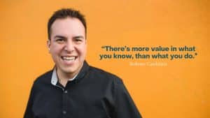 man standing in front of an orange wall “There’s more value in what you know, than what you do.”